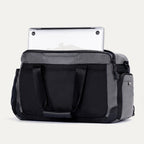 Rear view of the Travelpro Altitude Day-to-Day Duffel in Falcon Grey, showing laptop partially stowed in padded sleeve.
