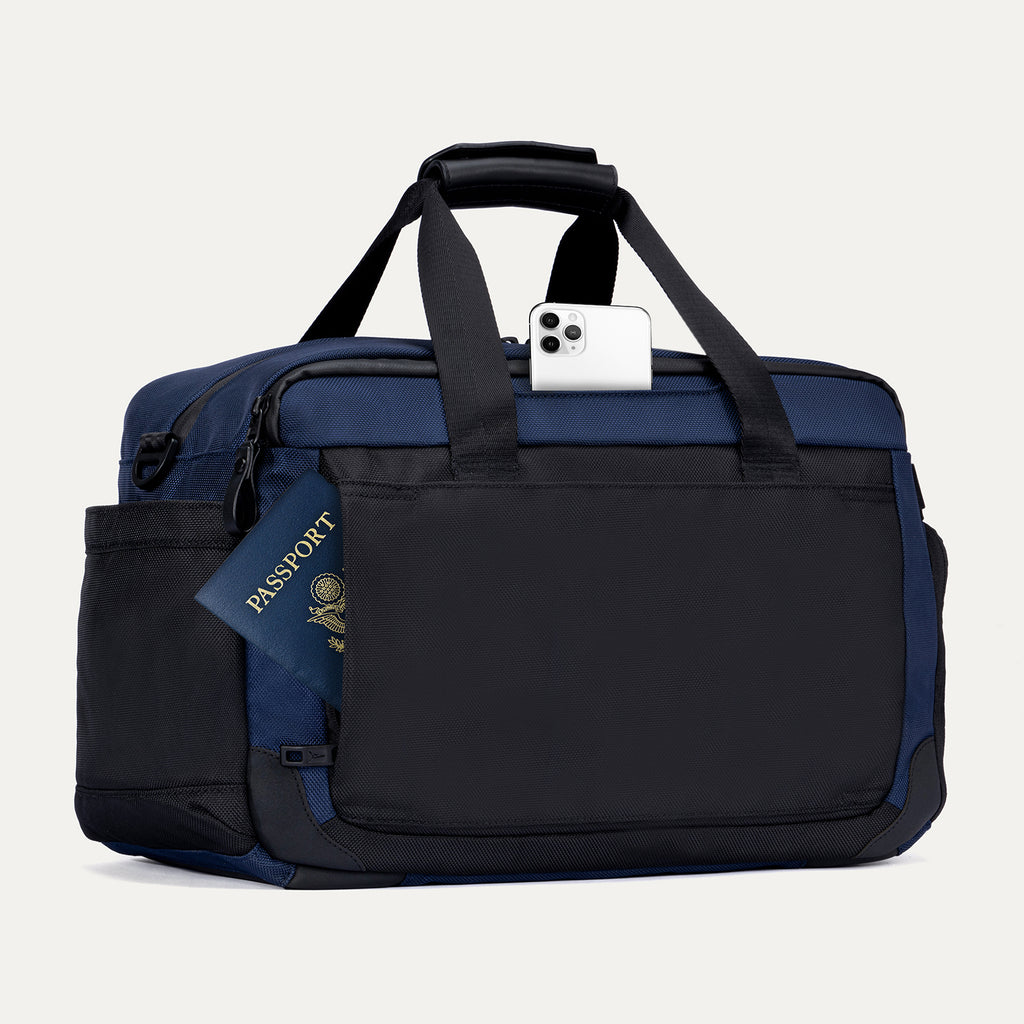 Rear view of the Travelpro Altitude Day-to-Day Duffel in Aviator Navy, showing phone and passport stored in exterior slip pockets.
