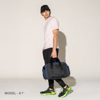 Person carrying a aviator navy duffel on a white background