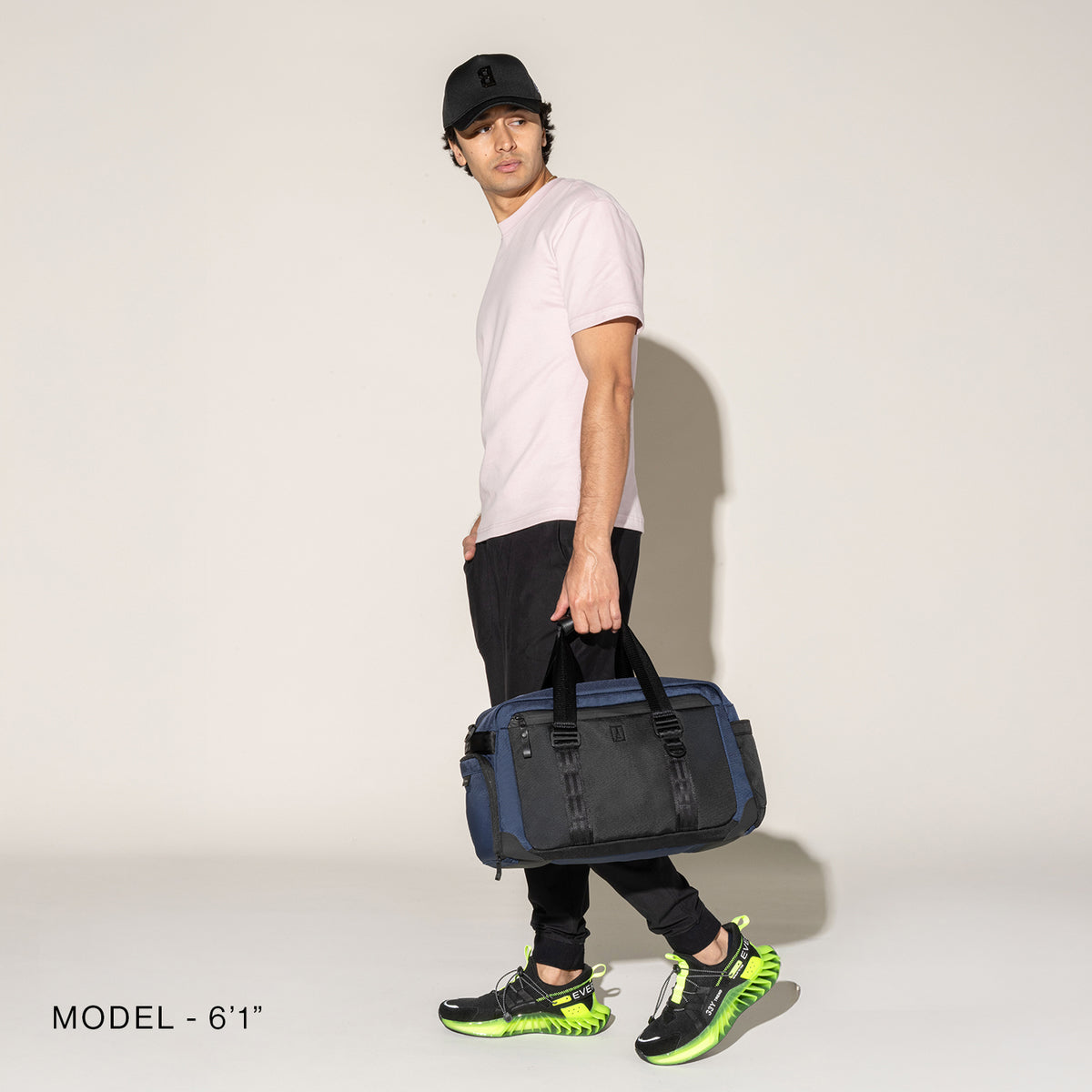 Person carrying a aviator navy duffel on a white background