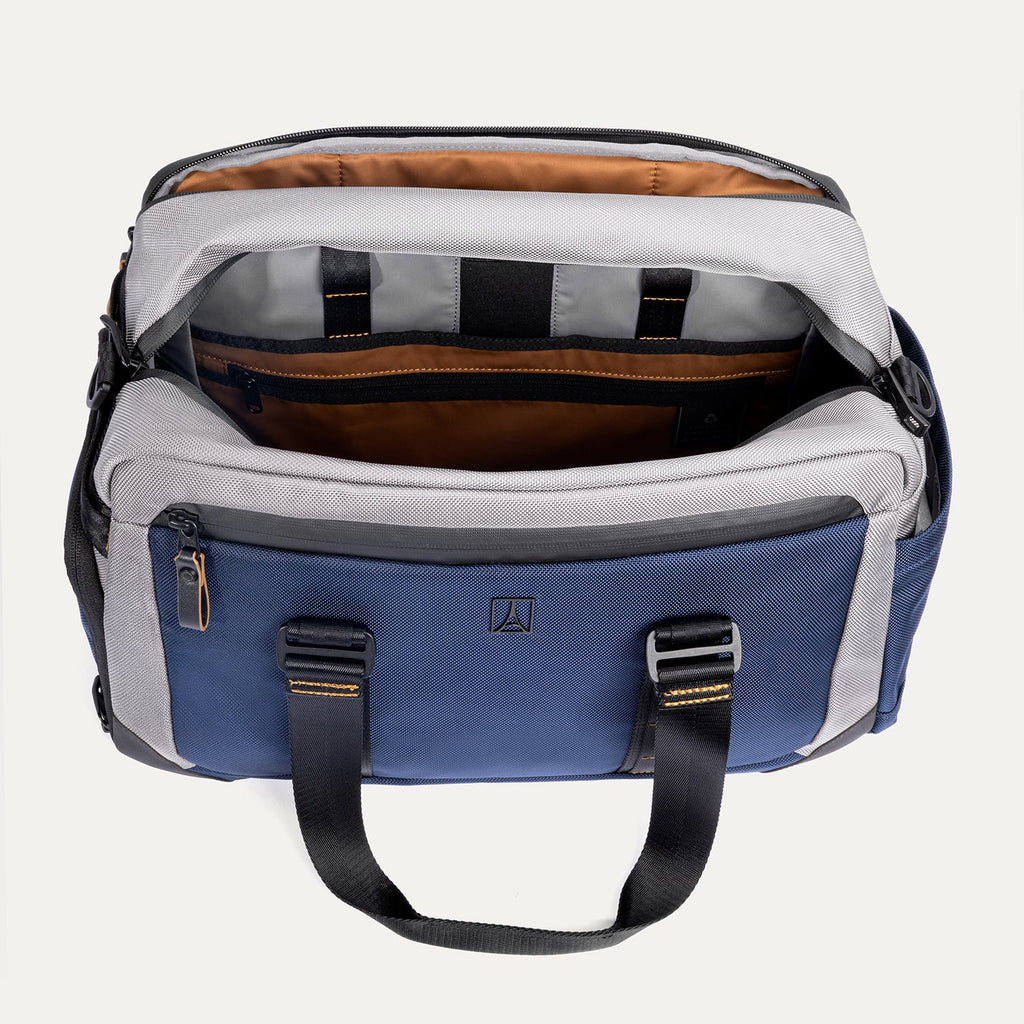 Top-down view of the Travelpro Altitude Day-to-Day Duffel in Stellar Navy/Grey, showing interior compartments with padded laptop sleeve.