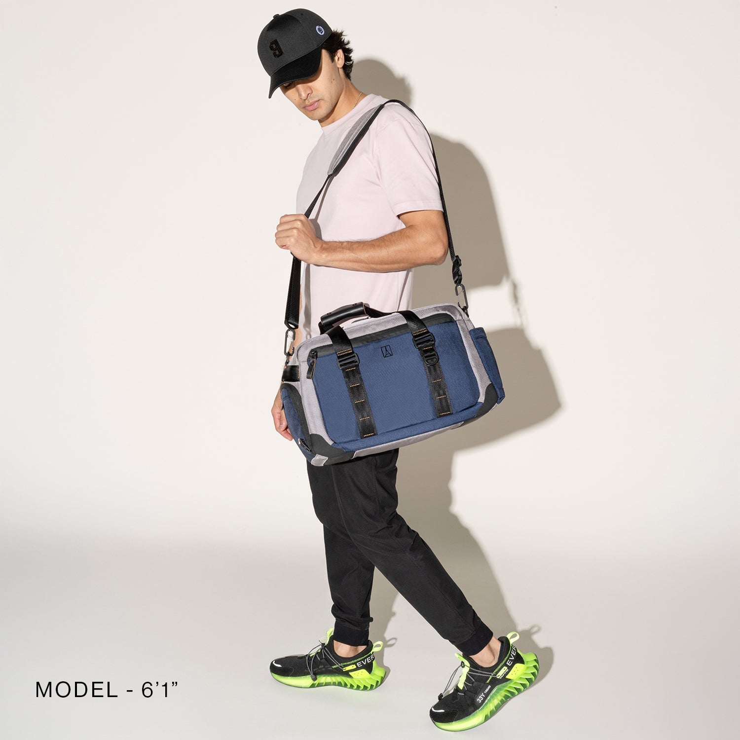 Person wearing a stellar navy duffel over the shoulder over the shoulder on a white background
