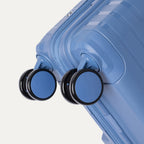 Blue suitcase with black wheels on a light gray background