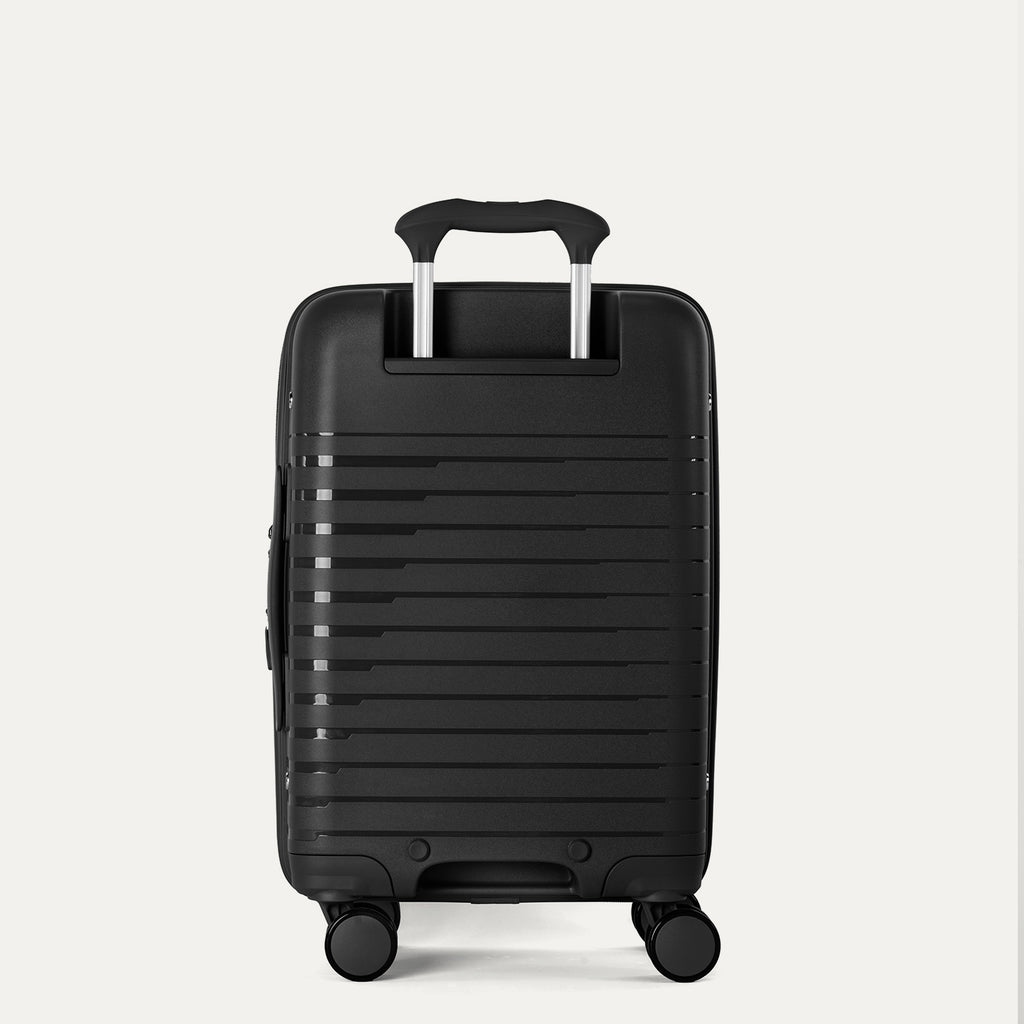 Black suitcase with a textured surface on a light gray background