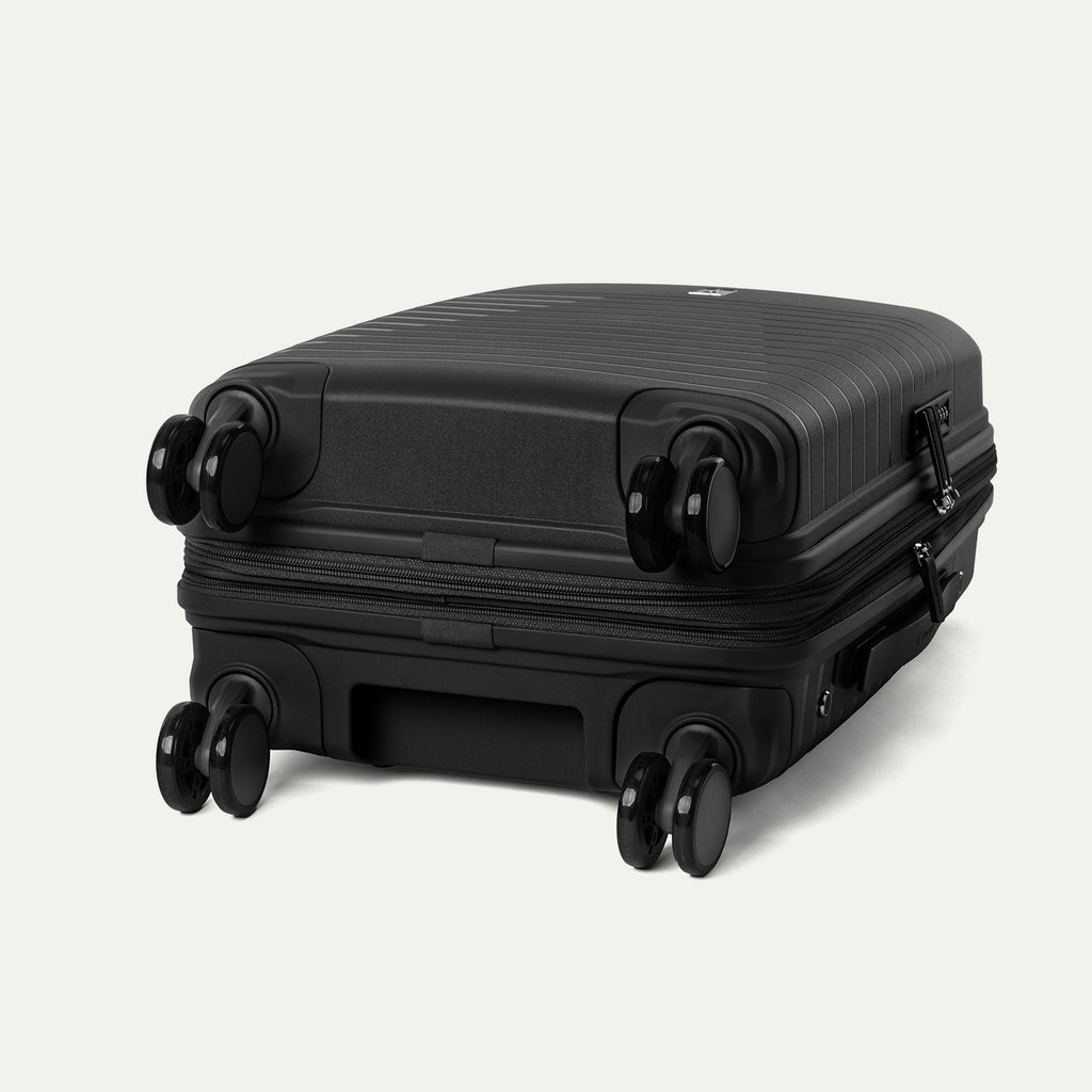 Black suitcase with wheels on a light gray background