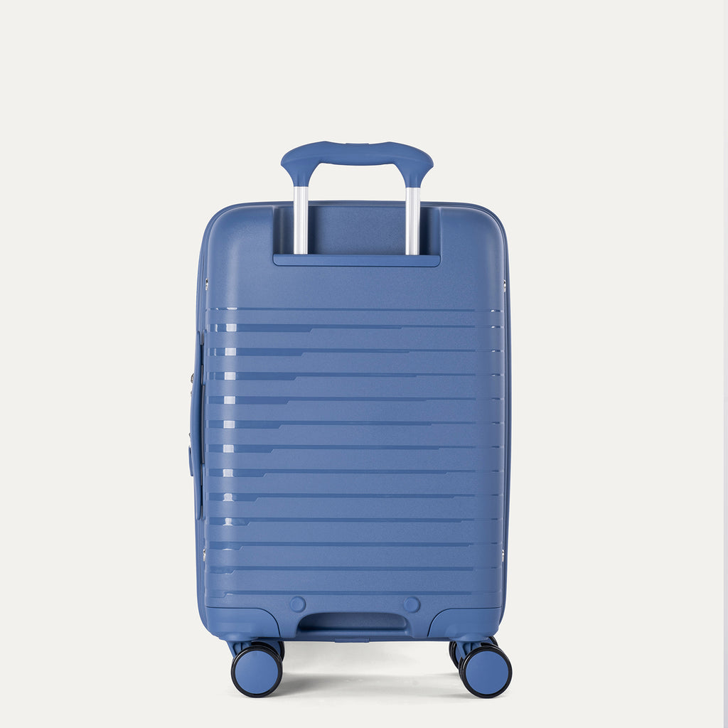 Rear-three-quarters view of the Horizon Blue Optima Expandable Carry-on Spinner, showing the extended PowerScope telescoping handle, textured hardside shell, and smooth-rolling multi-directional spinner wheels against a light gray background.