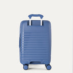 Rear-three-quarters view of the Horizon Blue Optima Expandable Carry-on Spinner, showing the extended PowerScope telescoping handle, textured hardside shell, and smooth-rolling multi-directional spinner wheels against a light gray background.