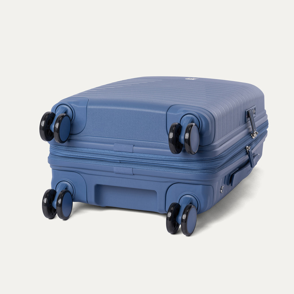 Bottom view of the Horizon Blue Optima Expandable Carry-on Spinner, highlighting the multi-directional spinner wheels and bottom grab handle against a light gray background.