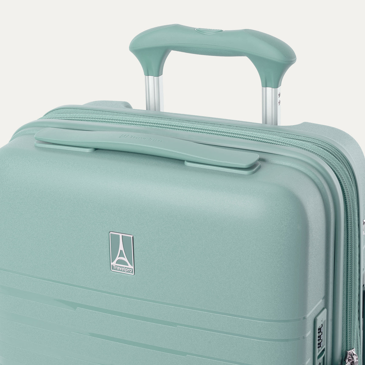 Close-up of the Optima Expandable Carry-on Spinner in Lunar Rock, showing the telescoping handle extended, a top handle grip, zipper, and the Travelpro logo badge on the front against a solid off-white background.