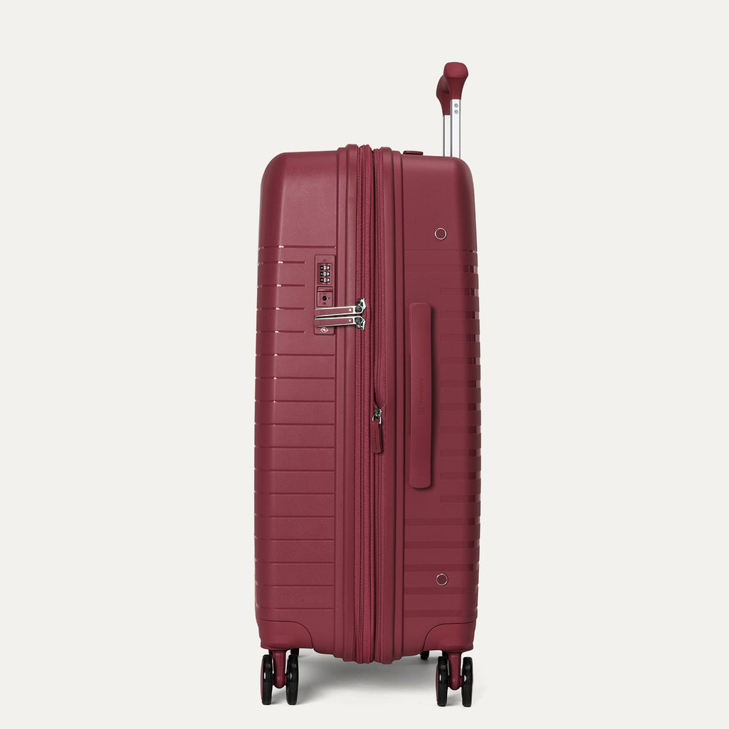 Maroon suitcase with wheels and handle on a light gray background