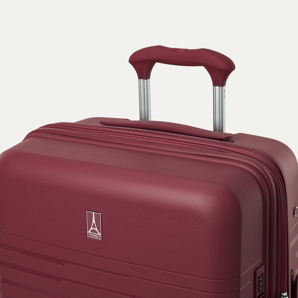 Maroon suitcase with handle on a light gray background