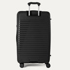 Black suitcase with a ribbed texture on a light gray background