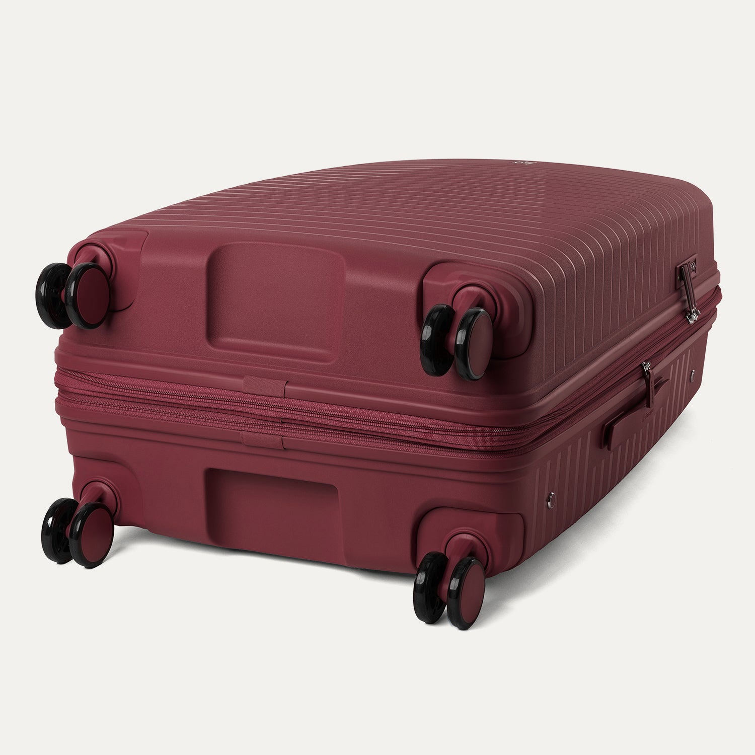 Maroon suitcase with wheels on a light gray background