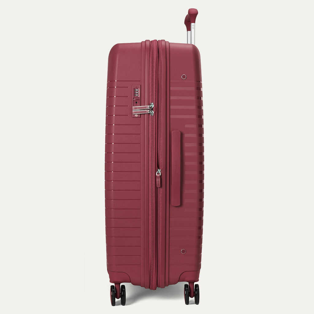 Maroon suitcase with wheels and handle on a light gray background