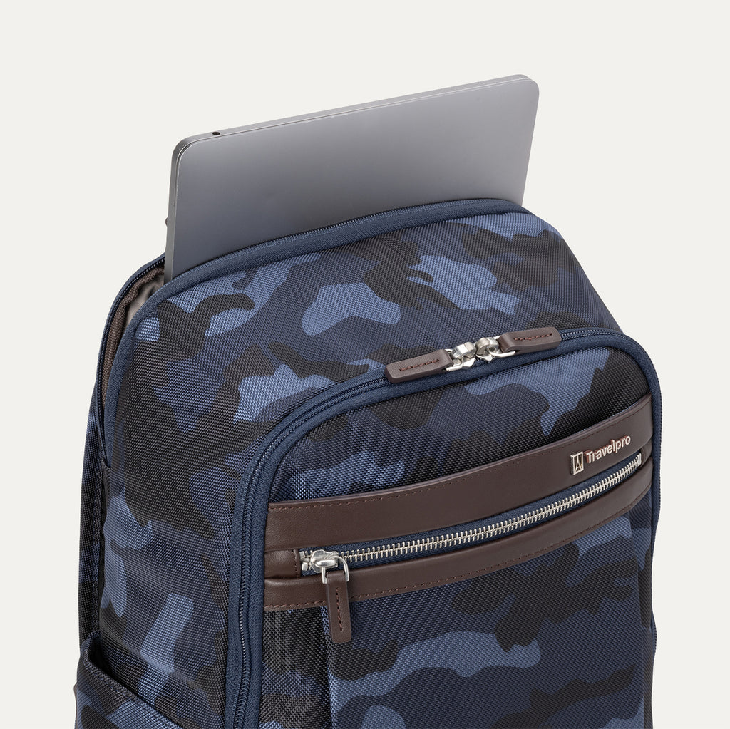 Top view of Travelpro Platinum Elite Slim Backpack in camouflage, showing a laptop partially tucked into the padded sleeve compartment.
