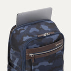 Top view of Travelpro Platinum Elite Slim Backpack in camouflage, showing a laptop partially tucked into the padded sleeve compartment.
