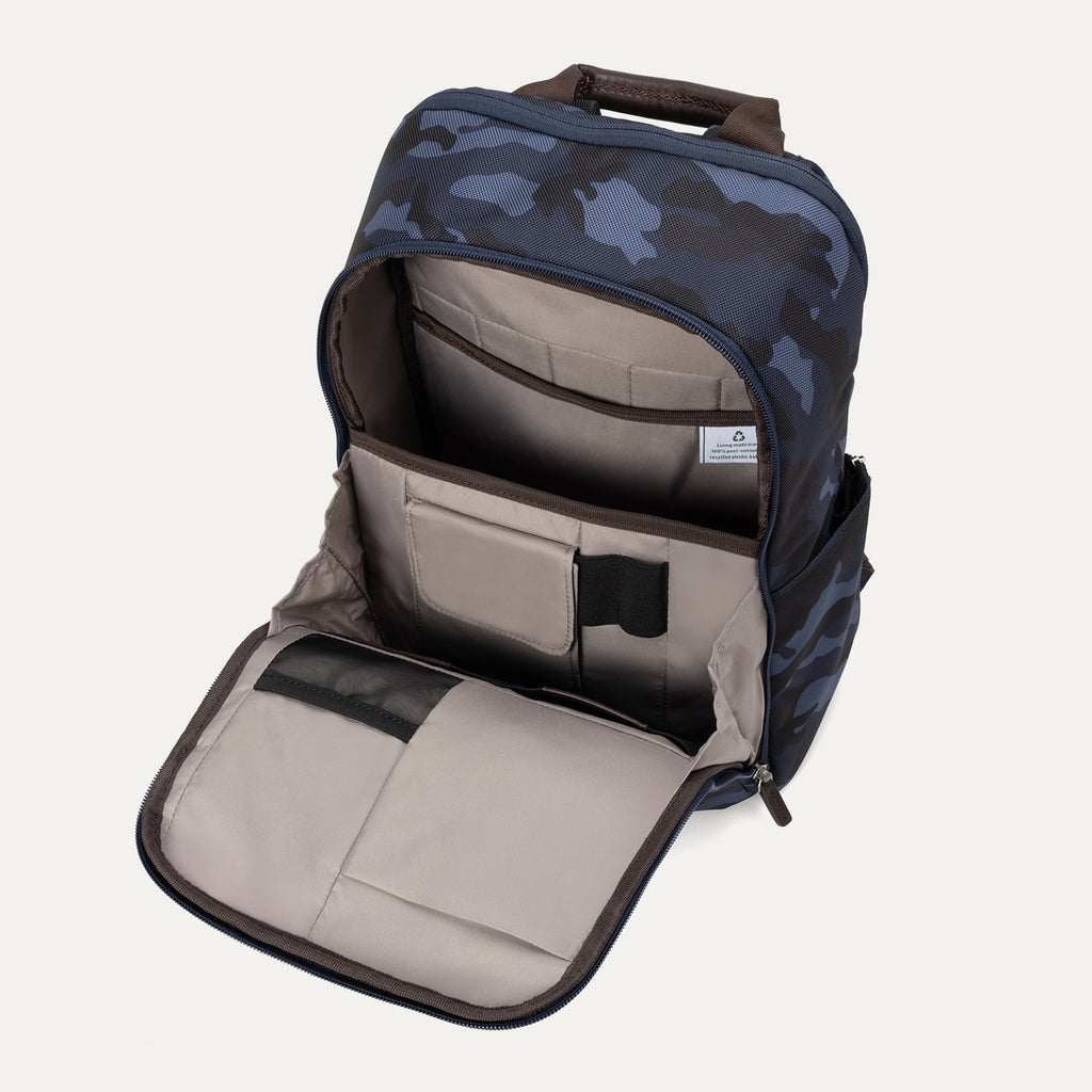 Interior view of the Travelpro Platinum Elite Slim Backpack in camouflage, showing padded laptop and tablet sleeves with organizational pouches.
