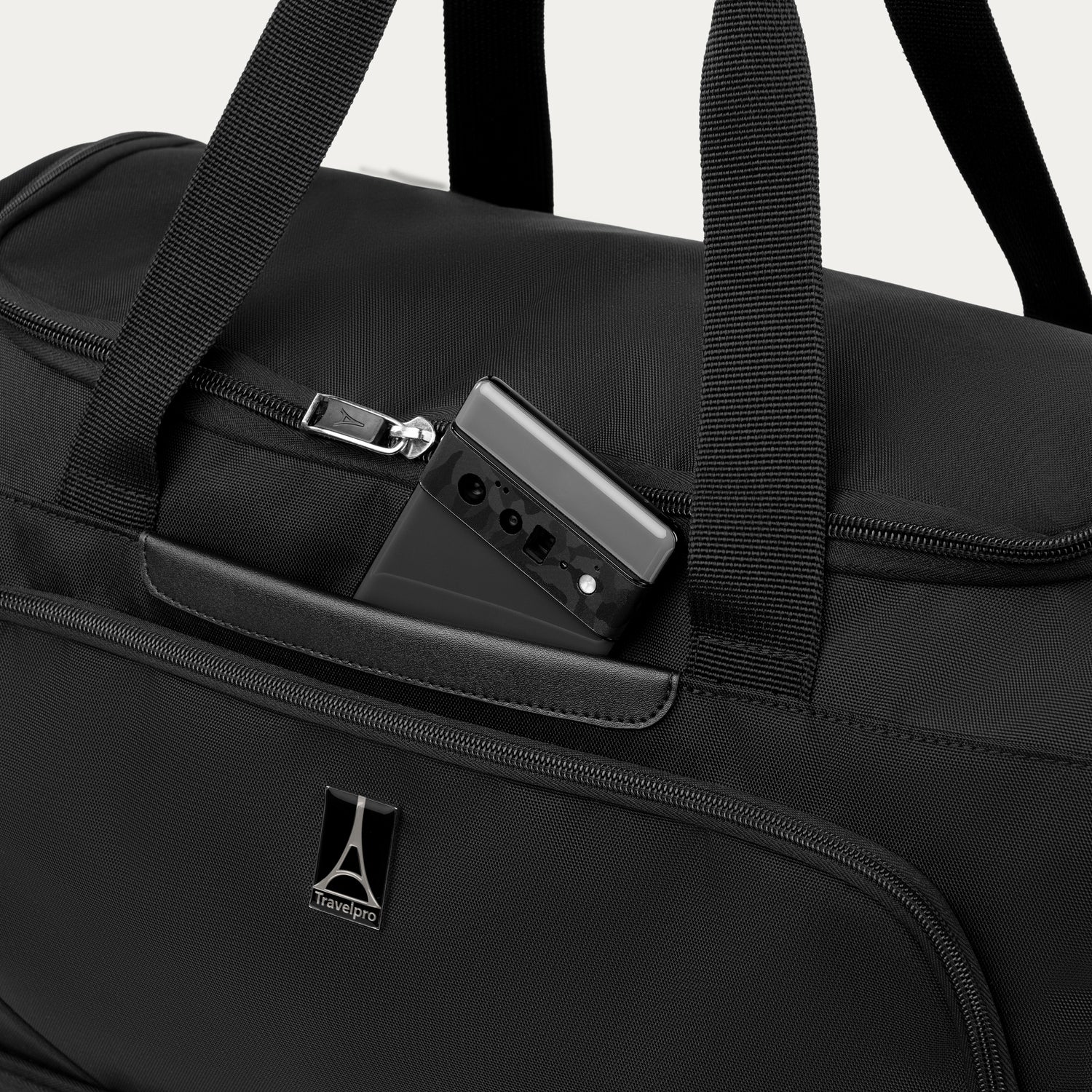 Black weekender with phone in QuickSlip™ pocket, featuring the Travelpro logo
