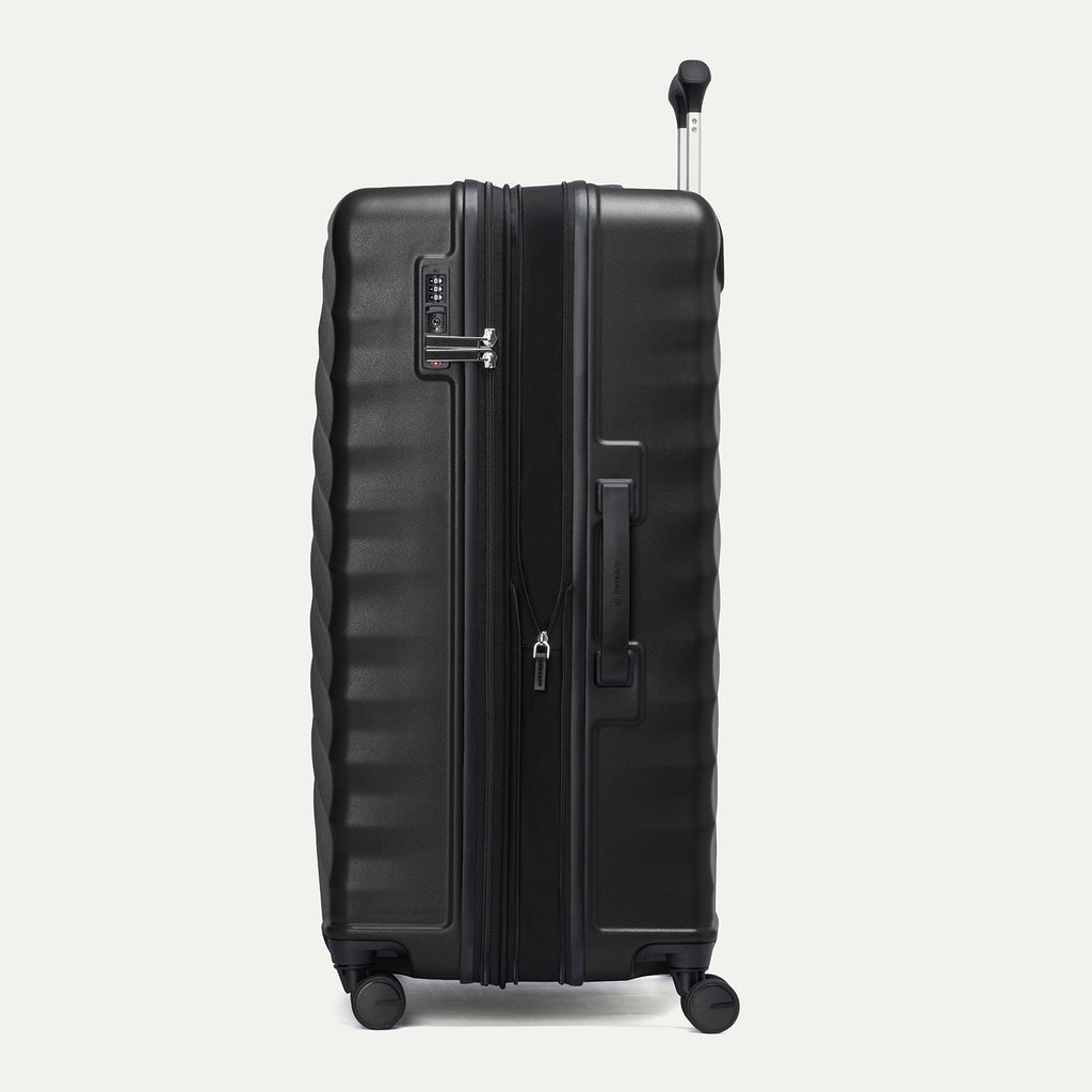 side profile of the black travelpro maxlite air v2 carry-on showing the integrated tsa lock, side carry handle, and expansion zipper.