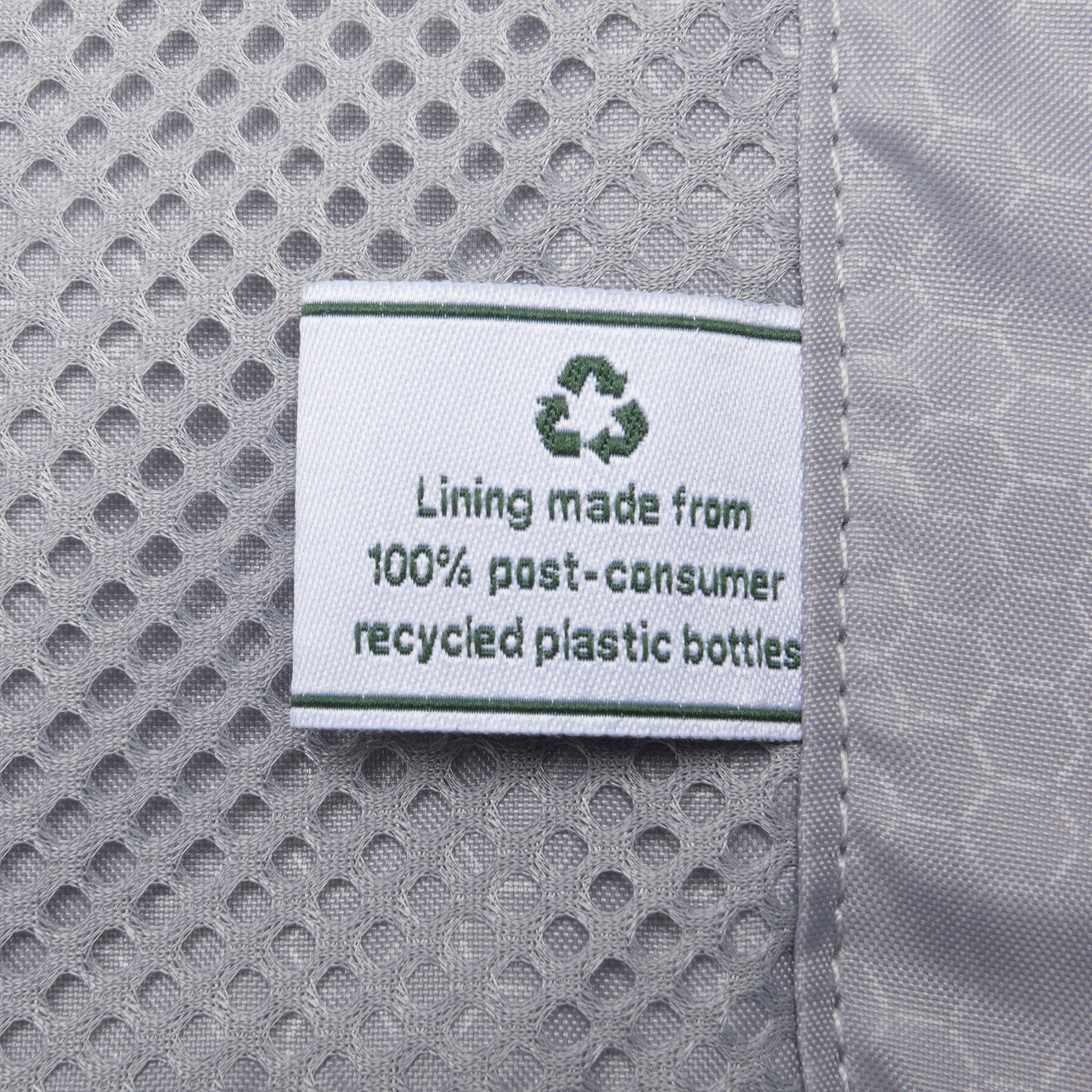 close up of the interior fabric tag on the travelpro maxlite air v2 stating the lining is made from 100 percent post consumer recycled plastic bottles.