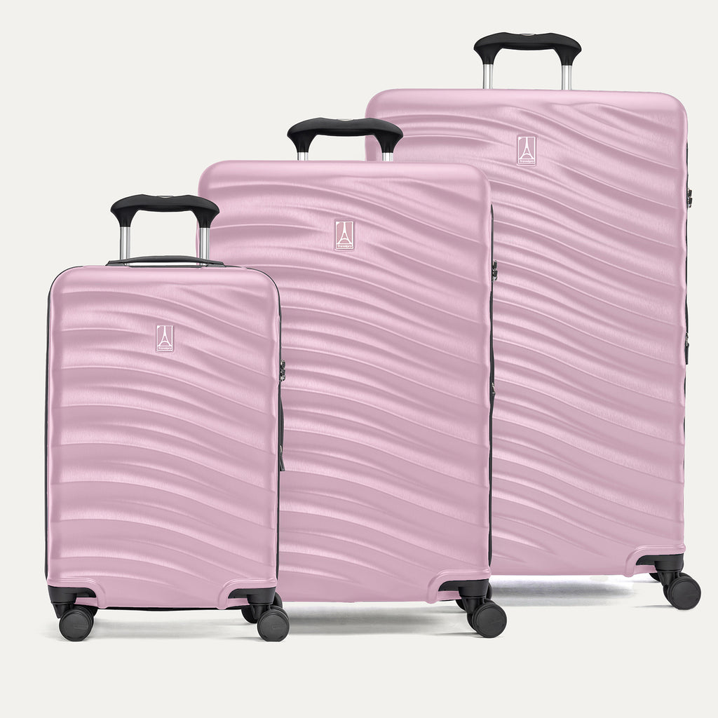 A set of three pink hardside spinner suitcases, including carry-on, medium, and large sizes on a white background