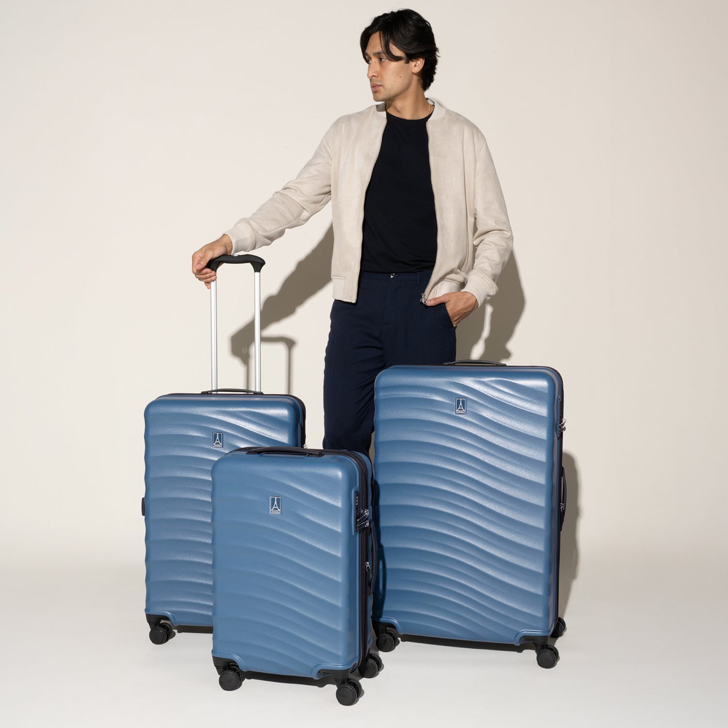 Man standing with the Travelpro Maxlite Air V2 Carry-On, Medium, and Large Check-In Set in Ensign Blue, featuring textured shell and 360° Spinner Wheels