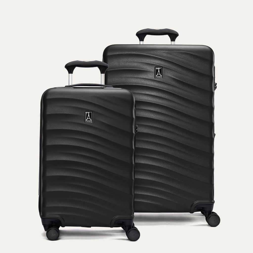 A set of two black hardside spinner suitcases, one carry-on size and one medium check-in size, with a textured surface, integrated handles, and wheels.