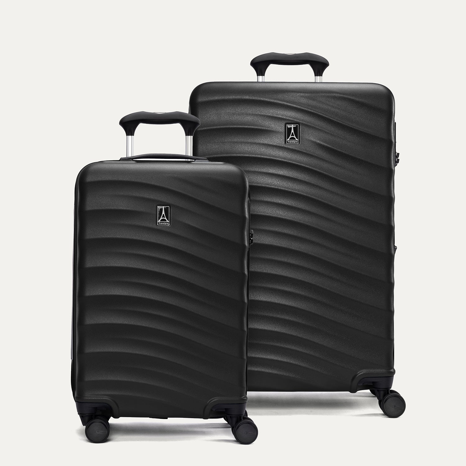 A set of two black hardside spinner suitcases, one carry-on size and one medium check-in size, with a textured surface, integrated handles, and wheels.