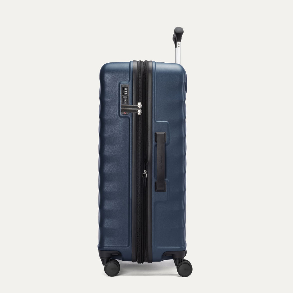 Side view of Travelpro Maxlite Air V2 Expandable Spinner in Midnight Blue, showing TSA Approved Locks and low-profile carry handle.
