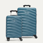 Two blue hardside suitcases with a visible brand logo on a light gray background