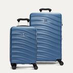 Two blue hardside suitcases with a visible brand logo on a light gray background