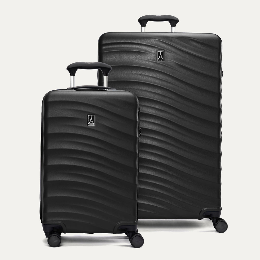A set of two black hardside spinner suitcases, one carry-on size and one large check-in size, with a textured surface, integrated handles, and wheels.