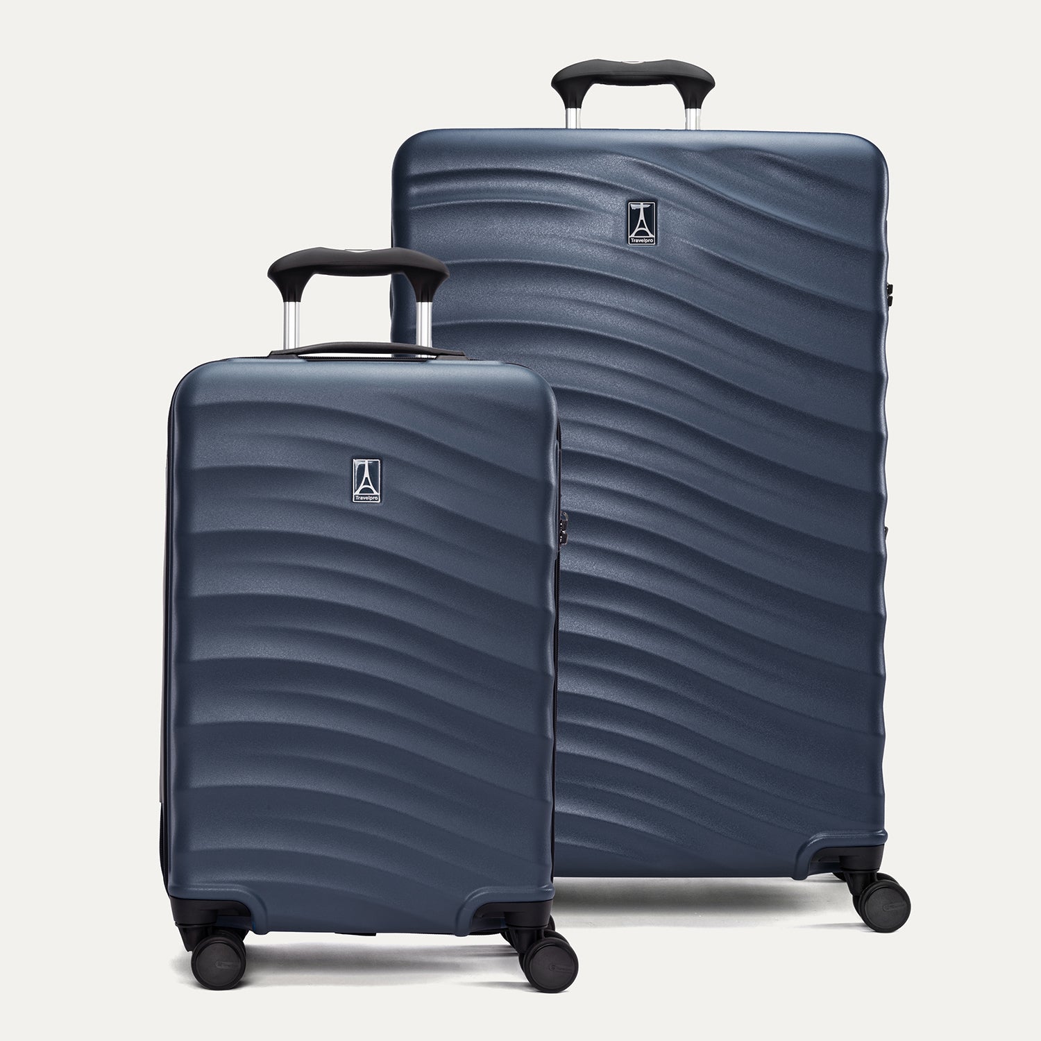 A set of two blue hardside spinner suitcases, one carry-on size and one large check-in size, with a textured surface, integrated handles, and wheels.