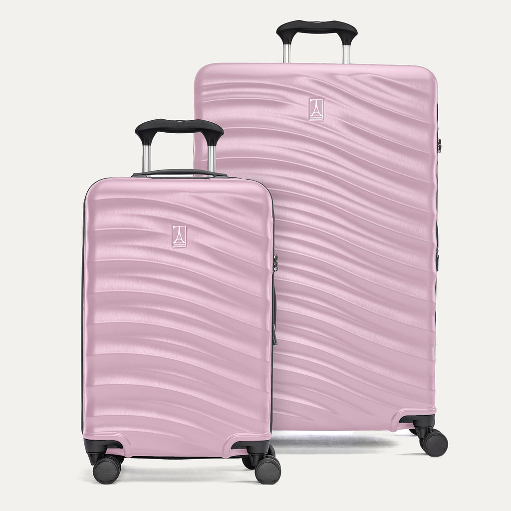 A set of two pink hardside spinner suitcases, one carry-on size and one large check-in size, with a textured surface, integrated handles, and wheels.