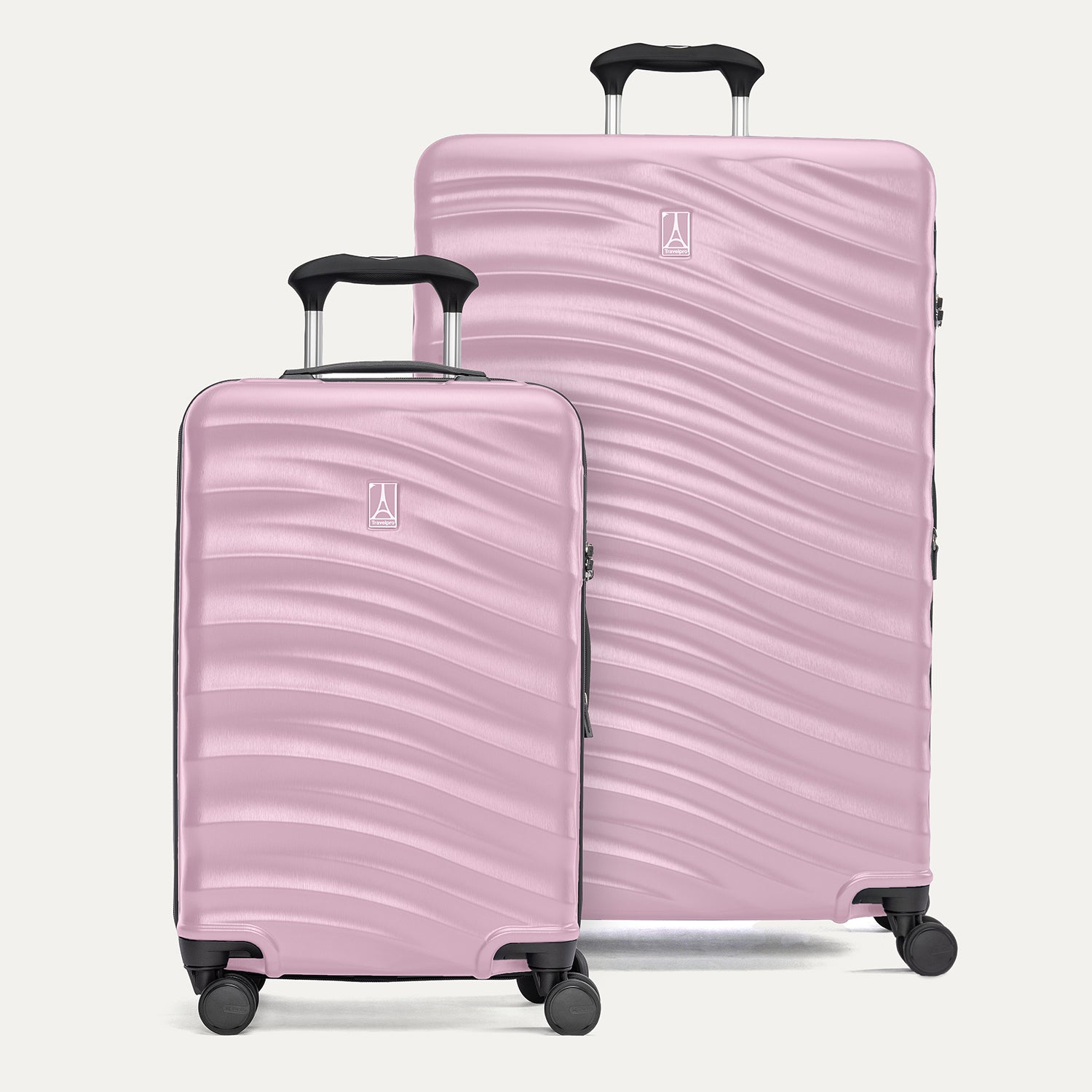 A set of two pink hardside spinner suitcases, one carry-on size and one large check-in size, with a textured surface, integrated handles, and wheels.