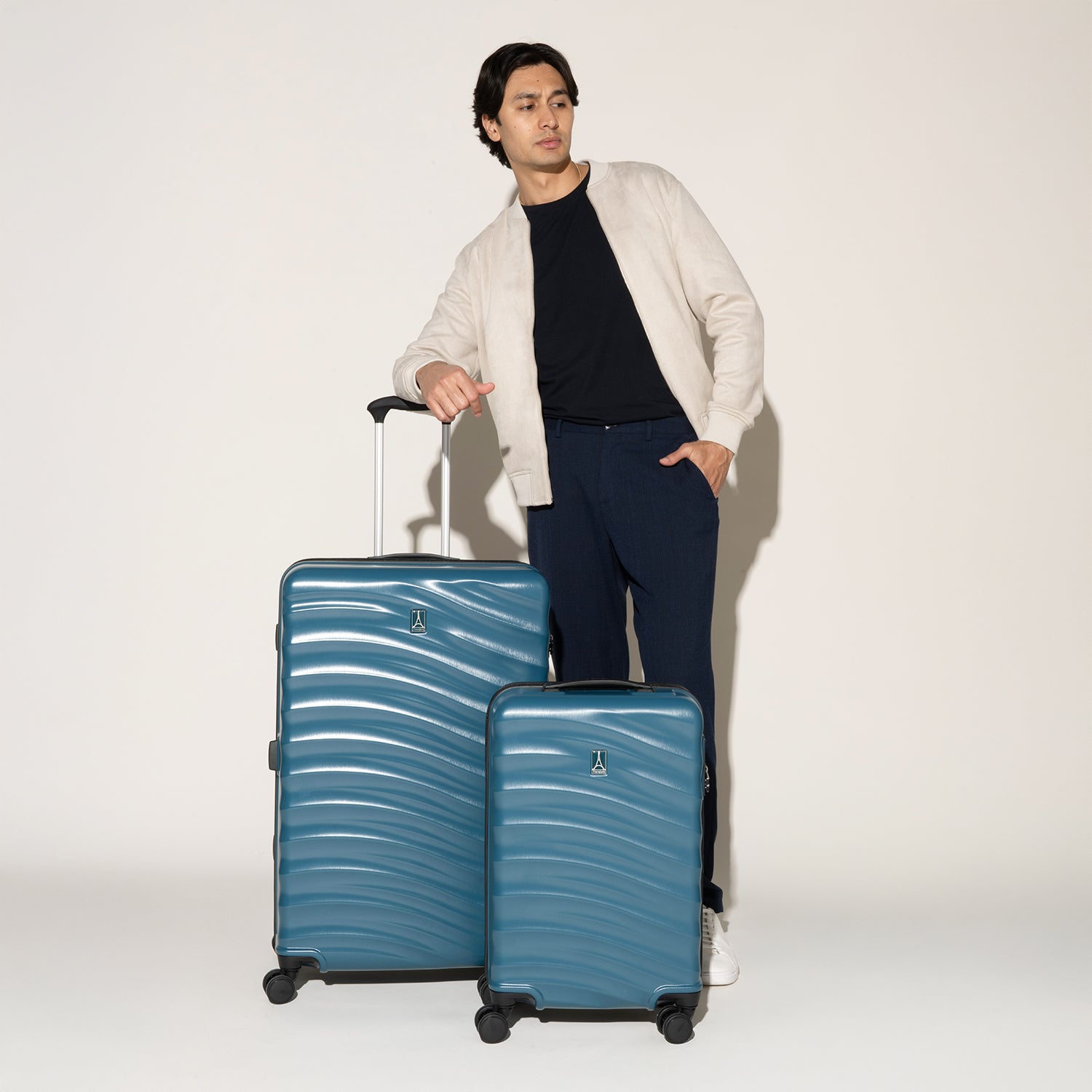 Man standing beside the Travelpro Maxlite Air V2 Carry-On and Large Check-In Set in Teal, featuring textured shell and 360° Spinner Wheels.