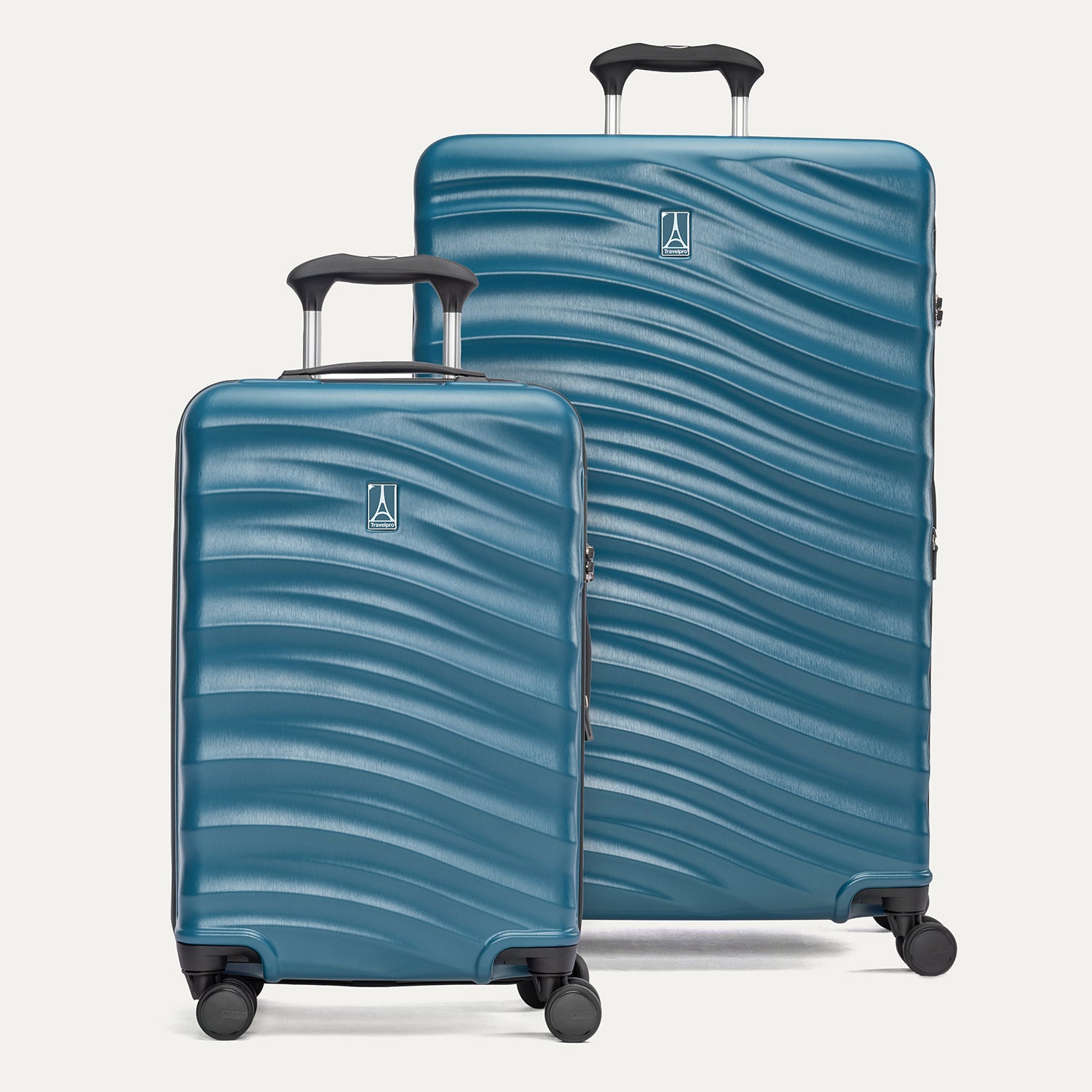 A set of two blue hardside spinner suitcases, one carry-on size and one large check-in size, with a textured surface, integrated handles, and wheels.