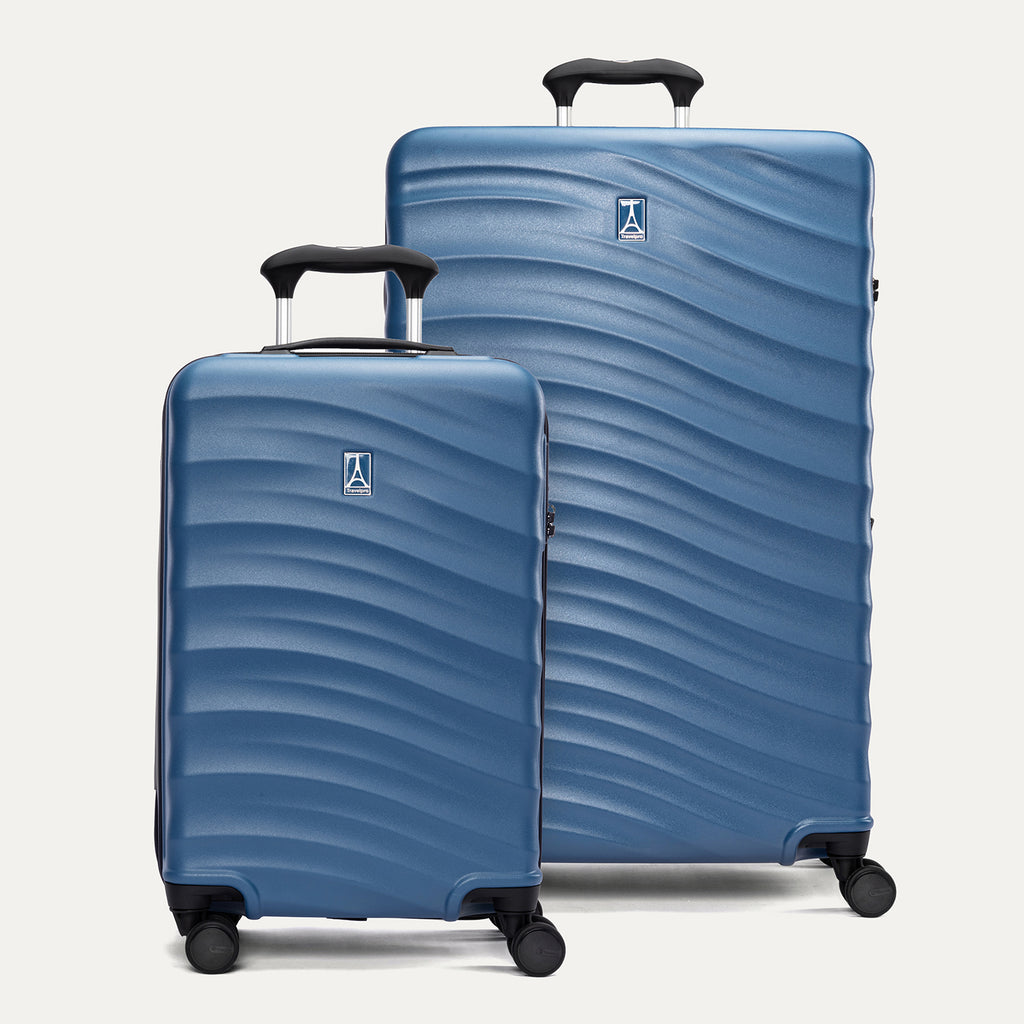 A set of two blue hardside spinner suitcases, one carry-on size and one large check-in size, with a textured surface, integrated handles, and wheels.