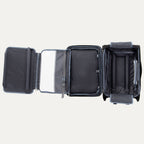 Black suitcase with open compartments  and suiter on a white background