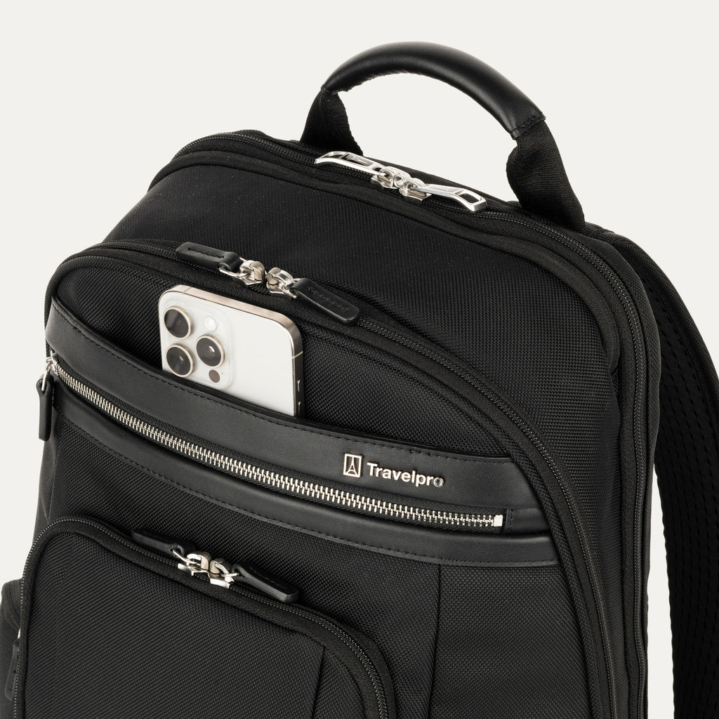 Black backpack with a phone in a pocket on a light gray background