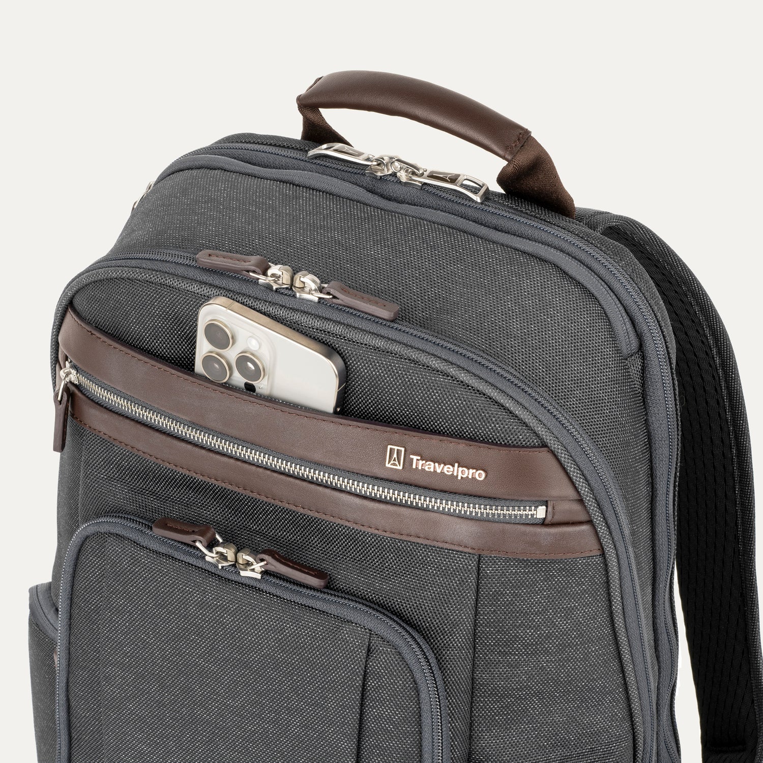 Gray backpack  with a cellphone sticking out of the front pocket with brown accents and a visible Travelpack logo on a white background