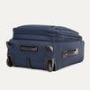 Blue suitcase laying on the ground expanded  with wheels and handle on a light gray background