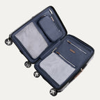 interior view of the open monaco blue travelpro x travel plus leisure hardshell spinner suitcase lying flat, showcasing its fully lined navy blue compartments, zippered privacy separator panels with built-in mesh and solid organizing pockets, and elegant brown leather zipper pulls.