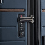 close-up detail view of the monaco blue travelpro x travel plus leisure suitcase, highlighting the integrated recessed TSA-approved combination lock with premium silver metal zipper pulls and elegant brown leather trim detailing against the durable textured hardshell exterior.