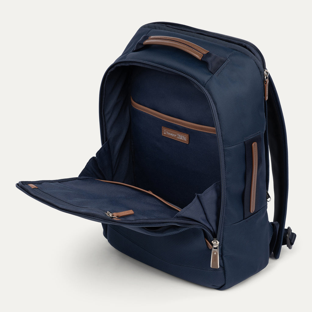 interior view of the open front compartment of the monaco blue travelpro x travel plus leisure slim backpack, showcasing its built-in organizational pockets with elegant brown leather trim, a dedicated tablet sleeve, and a premium navy blue lining.
