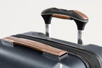 Close-up of a suitcase handle with brown accents on a white background