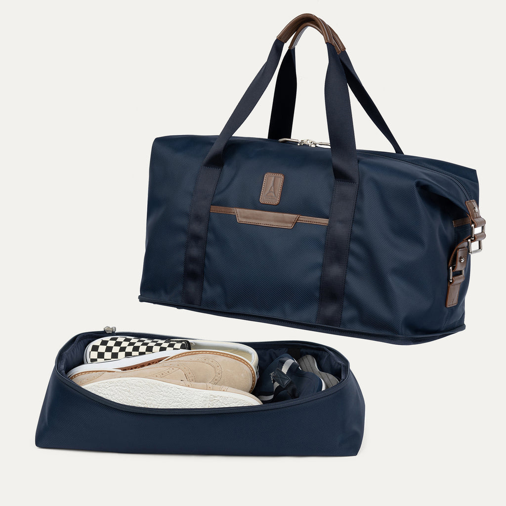 Navy blue weekender with open compartment showing shoes on a white background
