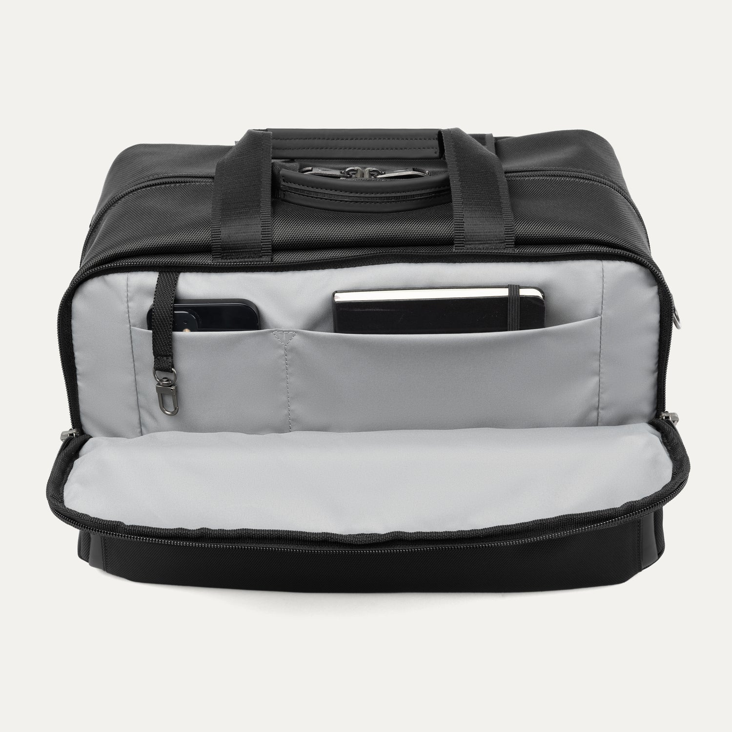 Black tote bag with interior compartments showing a phone and notepad on a white background