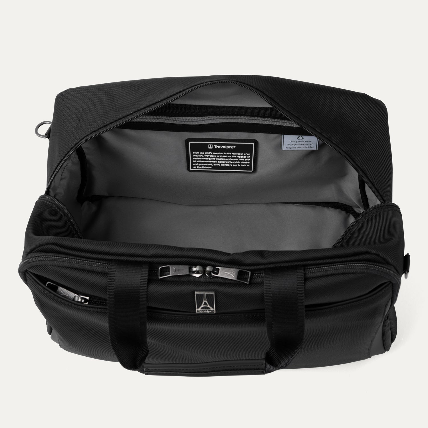 Interior of black tote bag with visible brand logos on a light gray background
