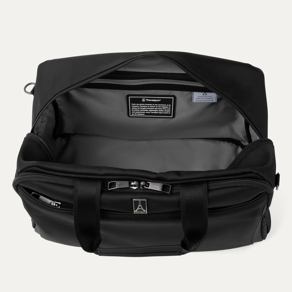 Interior of black tote bag with visible brand logos on a light gray background